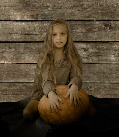 vintage, children. Pretty blond girl with a big pumpkinの写真素材