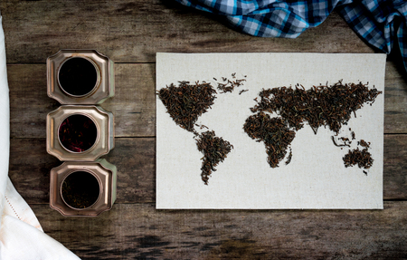 map of the world, lined with tea leaves on old paper. Eurasia, America, Australia, Africa. vintage. green tea on rustic wooden tableの写真素材