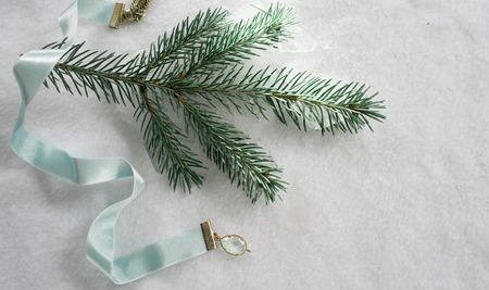 Satin blue ribbon and spruce twigs on a white background. top viewの写真素材