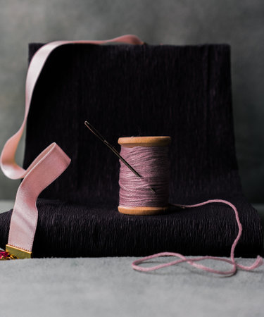 still life. an old reel of thread with a needle. close-up.