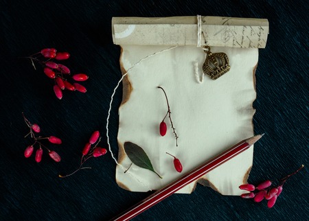 burnt paper, boxes, barberry berries on a dark background. top viewの写真素材