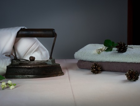 family. vintage. old cast-iron iron and pile of towels, cones.の写真素材