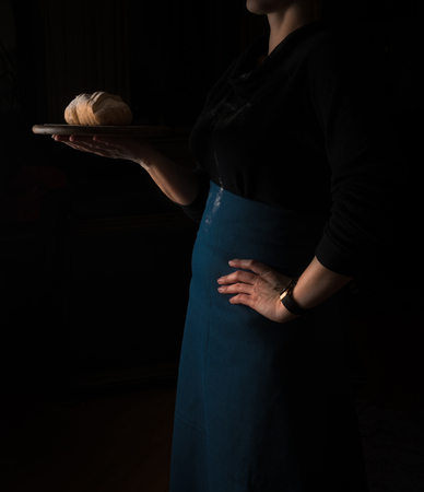 still life in the small Dutch-style. a woman holding a tray of bread.の写真素材