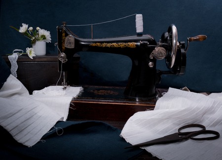 Classic retro style manual sewing machine ready for sewing work, scissors, fabric and old scissorsの写真素材