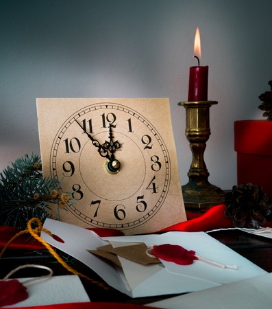 Christmas background with clock, snow fir tree and gift boxes over wood. letters invitationsの写真素材