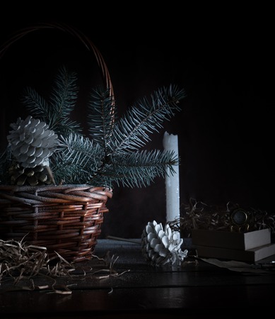 christmas, basket with fir branches and cones on a dark background.の写真素材