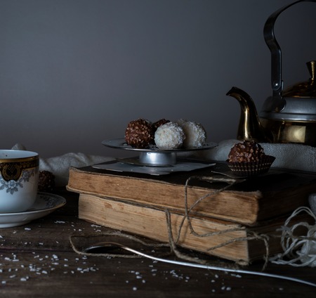 vintage. candy, drapery, metal teapot on a wooden table. dark backgroundsの写真素材