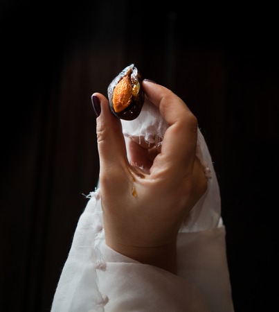 hand holding plum isolated on dark backgroundの写真素材