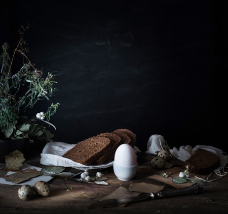 simple country breakfast on a wooden table. bread, eggs. black backgroundの写真素材