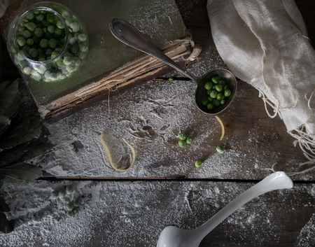 rustic still life, vintage. green peas, old books, flour on a wooden table. top viewの写真素材
