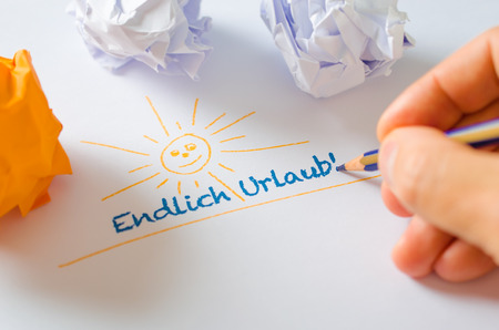 Hand writing holiday-message in german on white paper