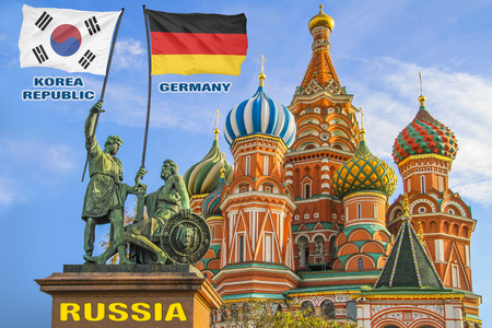 Flags of Korea Republic and Germany being held by two warriors on a statue in front of a Saint Basil's Cathedral in Moscow, Russiaの写真素材