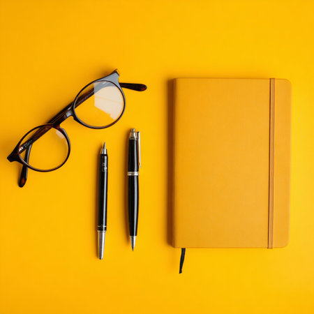 Top view of notebook, glasses and pen on yellow background. Flat lay