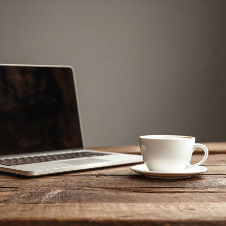 Coffee cup and laptop on a wooden table with copy spaceの写真素材