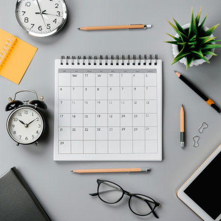 Top view of office desk table with calendar, clock, supplies and coffee cup