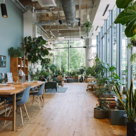 Interior of a modern cafe with wooden tables, chairs and plants