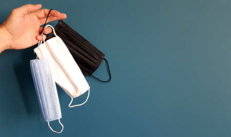 Three colors of face masks, protection for coronavirus pandemic, concept on blue backgroundの写真素材