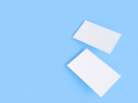 render 3d images of business cards dynamically scattered on a blue background.の写真素材