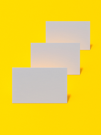 render 3d images of business cards dynamically scattered on a yellow background.の写真素材