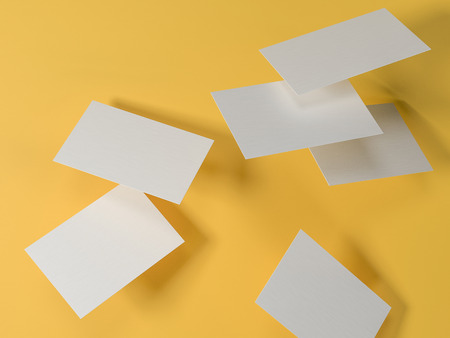 render 3d images of business cards dynamically scattered on a yellow background.の写真素材