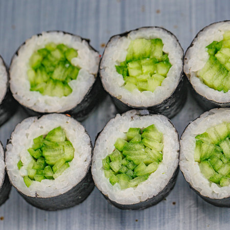 A varied assortment of sushi rolls, with different types and toppings, placed neatly on a table.の写真素材