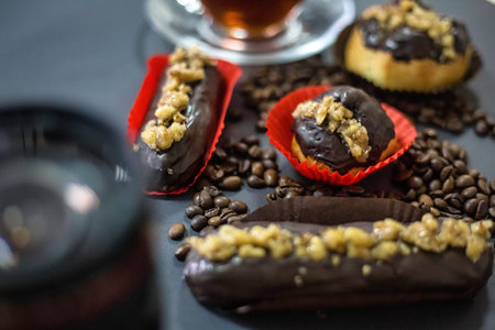 A table showcasing a variety of chocolate-covered donuts accompanied by a scattering of coffee...