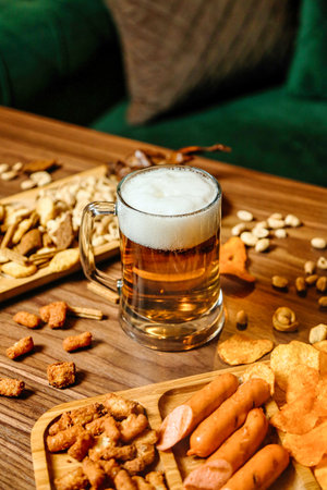 A wooden table covered with a variety of delicious food and a mug of beer.の写真素材