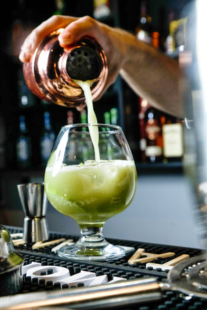 A person carefully pours a drink into a glass, creating a refreshing and satisfying moment.