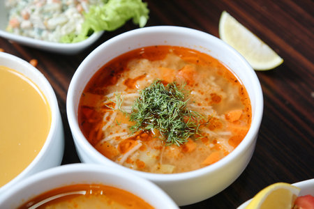 Four bowls of soup with various garnishes arranged on a table.