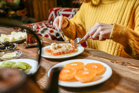 A woman is seated at a table, surrounded by various plates of delicious food.の写真素材