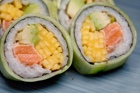 A detailed view of a sushi roll with a side of corn on the cob, showing the combination of Japanese and Western flavors.の写真素材