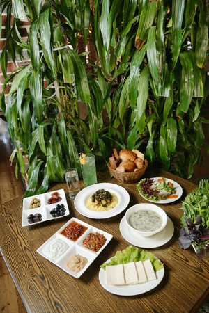A rustic wooden table is adorned with an assortment of deliciously prepared plates of food.