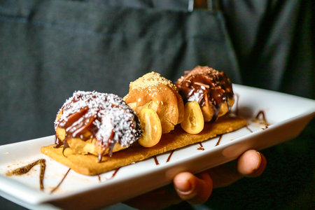 A person holds a white plate filled with delicious donuts, showing the mouth-watering treats.