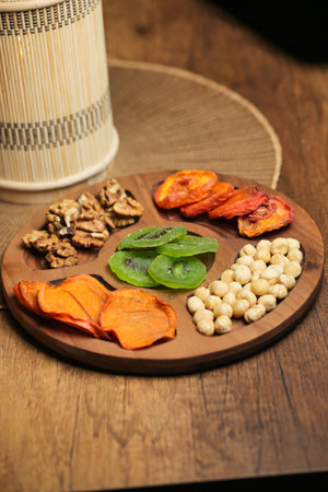 A wooden plate filled with a variety of different types of food, beautifully presented and ready to be enjoyed.の写真素材