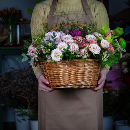 A person holding a basket filled with flowers, providing space for additional content.の写真素材