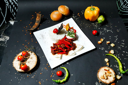A plate filled with mouth-watering food placed on a sleek black table.の写真素材