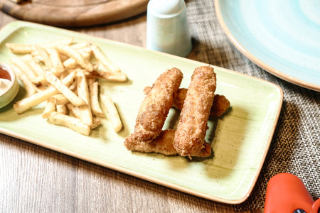 A plate filled with crispy French fries and accompanied by a savory dipping sauce.