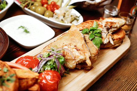 A wooden cutting board showcasing the half of a sandwich, neatly arranged and ready to be served.の写真素材