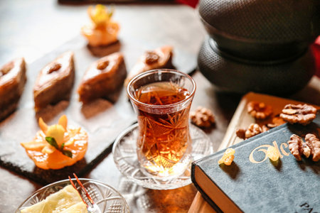 A table is seen with a glass of tea placed next to a book.の写真素材