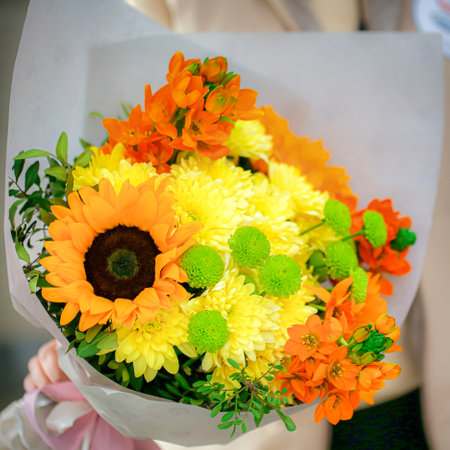 A person holds a vibrant bouquet of flowers in their hands, with copy space available.の写真素材