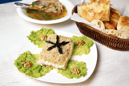 A simple white plate is adorned with a variety of delicious food items, placed next to a rustic...