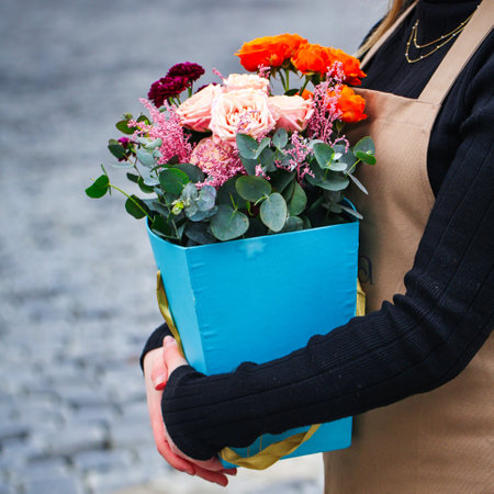 An image of a woman holding a blue box with flowers, leaving space for adding text or design.の写真素材