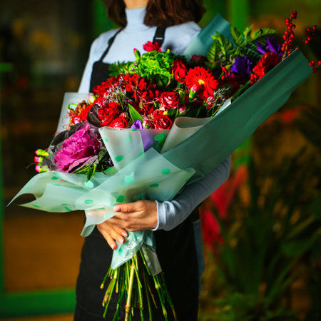 A woman gently holds a beautiful bouquet of flowers, creating a serene and captivating image.の写真素材