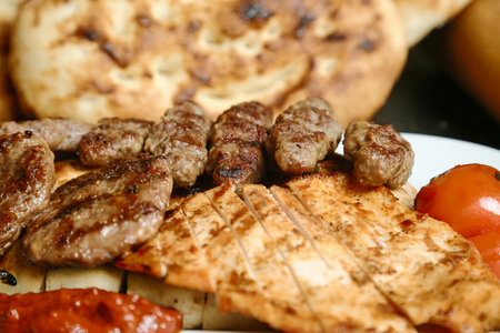A white plate is topped with a delicious assortment of meat and vegetables.
