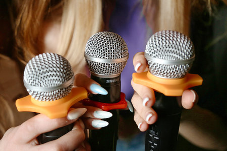 A woman confidently holds two microphones as she prepares to perform on stage.の写真素材