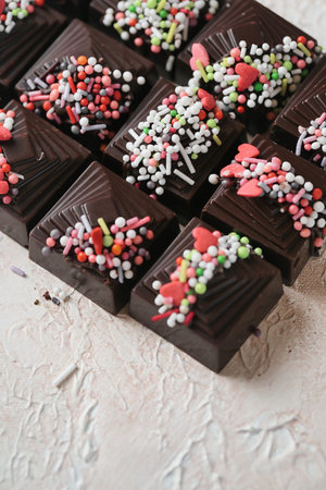 A detailed view of a tray filled with assorted chocolates, each adorned with colorful sprinkles.
