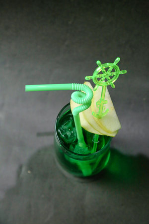 A photo capturing a green drink with a green straw, showcasing a refreshing beverage.の写真素材