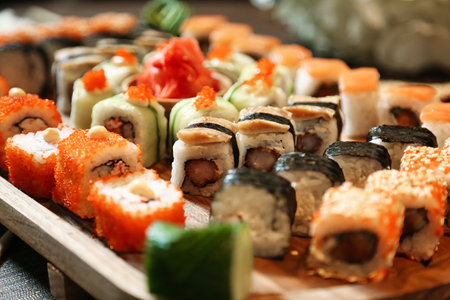 A platter filled with a variety of sushi rolls and nigiri is presented on a table.の写真素材