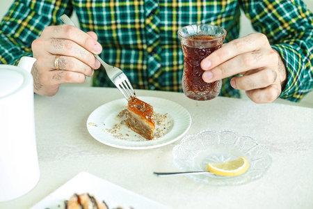 A person is sitting at a table, enjoying a meal with a plate of food in front of them.
