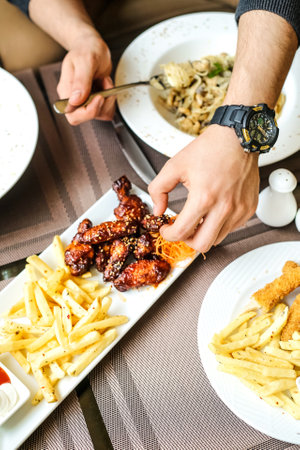 A person skillfully uses a knife to cut up food on a plate.の写真素材